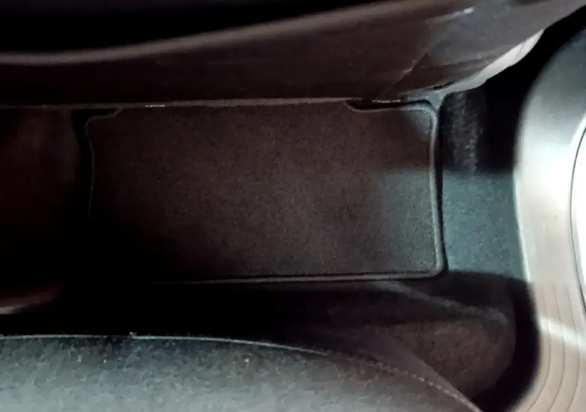 Tapis de sol noir côté conducteur de la Renault Clio Business blanche 2021 avec pédalier visible à droite.