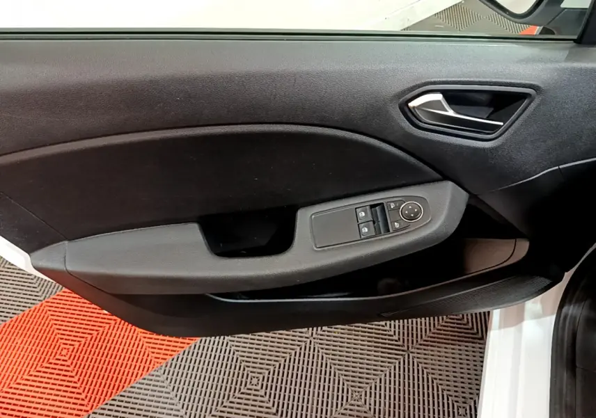 Gros plan sur la porte avant gauche noire de la Renault Clio Business blanche, avec commandes électriques des vitres et rétroviseurs.