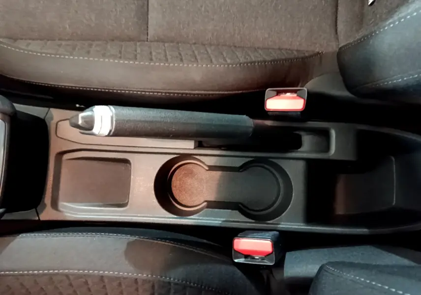 Vue plongeante sur la console centrale noire avec frein à main et porte-gobelets de la Renault Clio Business blanche 2021