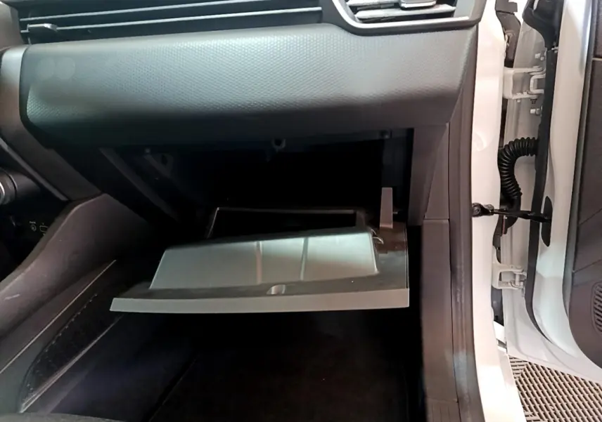 Vue rapprochée de la boîte à gants ouverte côté passager d'une Renault Clio Business blanche de 2021.