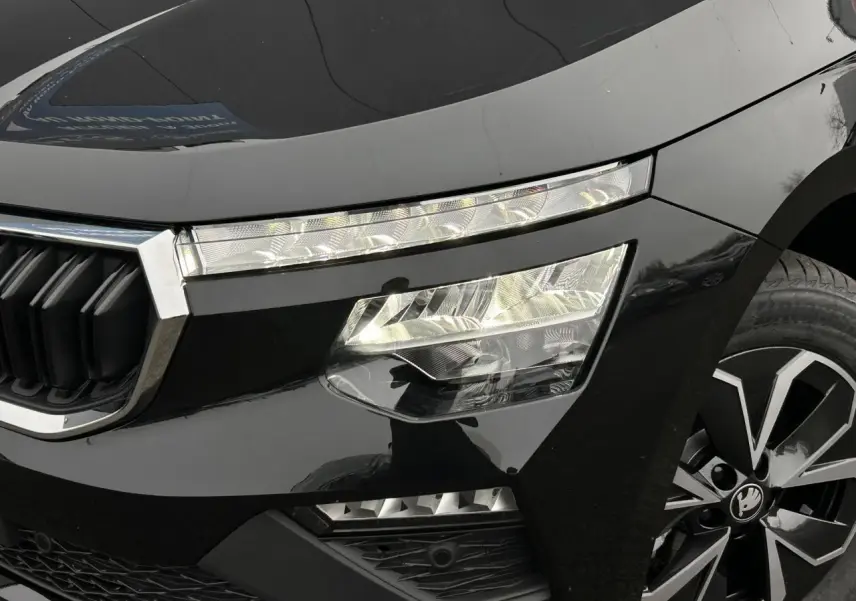 Gros plan sur l'avant droit noir Magic du Skoda Kamiq 2025, mettant en valeur les phares Full LED et la jante alliage.