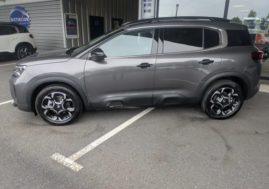 Vue de profil côté gauche du Citroën C5 Aircross hybride gris platinium avec jantes alliage biton 18 pouces.