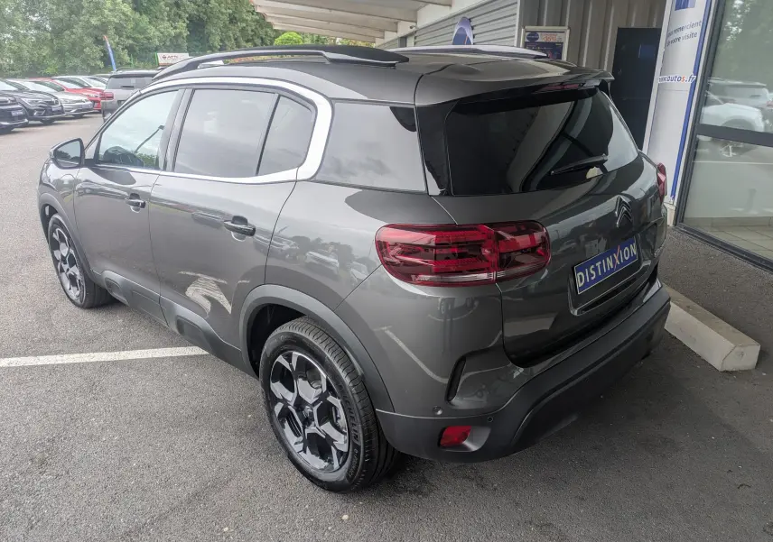 Vue 3/4 arrière droite du Citroën C5 Aircross hybride gris platinium avec jantes alliage biton et vitres arrière surteintées.