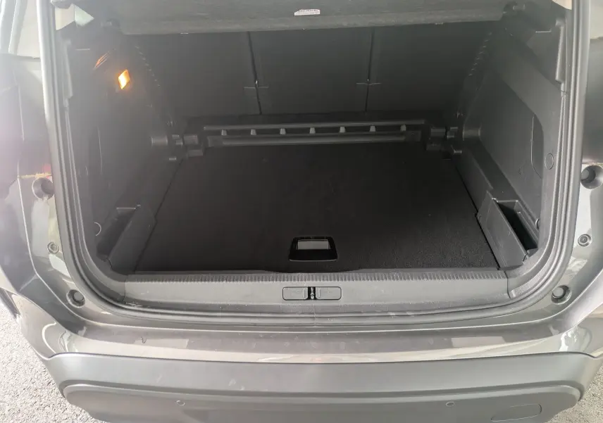 Coffre ouvert vu de l'arrière du Citroën C5 Aircross hybride gris platinium, montrant l'espace de chargement vide.