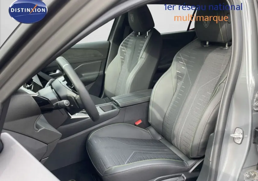 Vue intérieure côté conducteur de la Peugeot 308 gris selenium, sièges sport en tissu et cuir avec surpiqûres vertes.