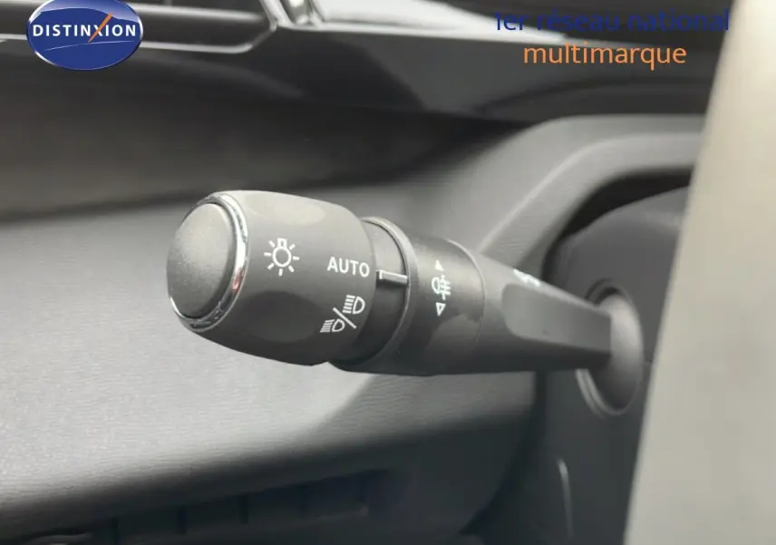 Gros plan sur la commande des phares automatique dans l’habitacle de la Peugeot 308 gris Selenium Hybrid 2026.