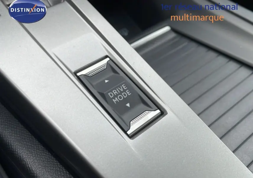 Gros plan sur le bouton Drive Mode gris argenté au centre de la console intérieure de la Peugeot 308 1.2 Hybrid 145ch GT 2026.