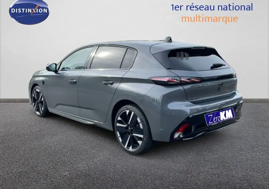 Vue 3/4 arrière droite d'une Peugeot 308 gris selenium métal avec jantes noires et détails LED arrière.