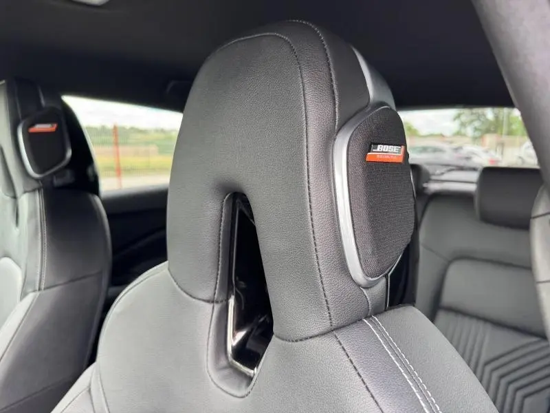 Gros plan sur l'appuie-tête avant gauche en cuir noir avec haut-parleur Bose intégré dans un Nissan Juke 2025.