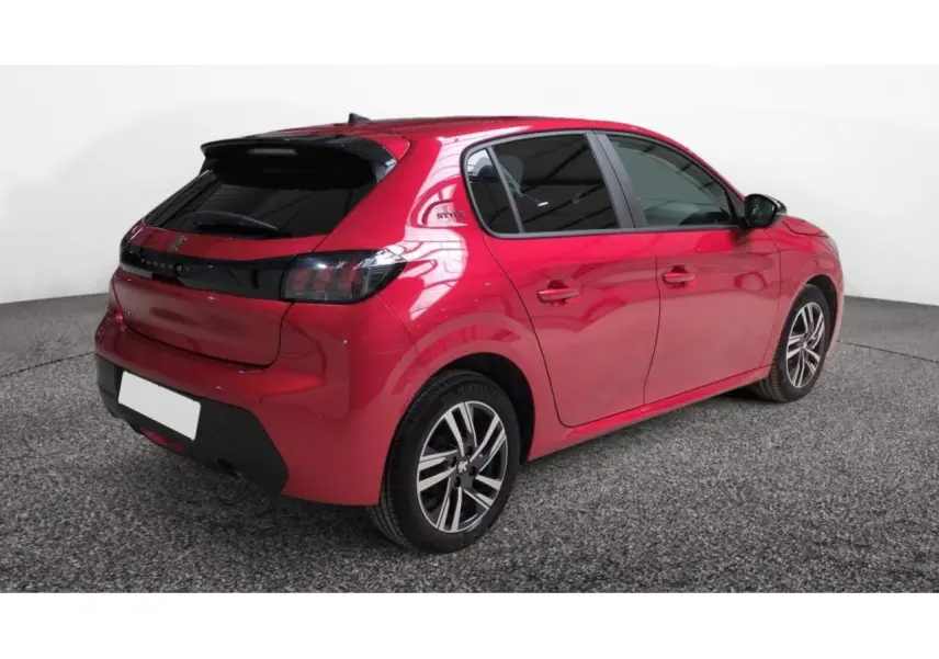 Vue 3/4 arrière droite d'une Peugeot 208 2024 rouge Elixir avec toit noir et jantes alliage distinctives.
