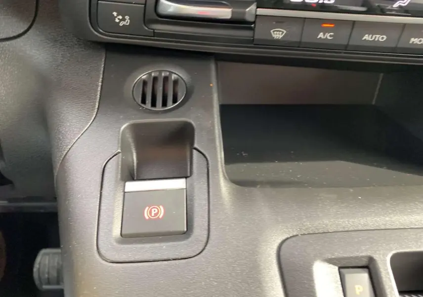 Gros plan sur la console centrale du Citroën Berlingo Multispace blanc 2025, montrant le frein à main électrique et commandes climatisation.