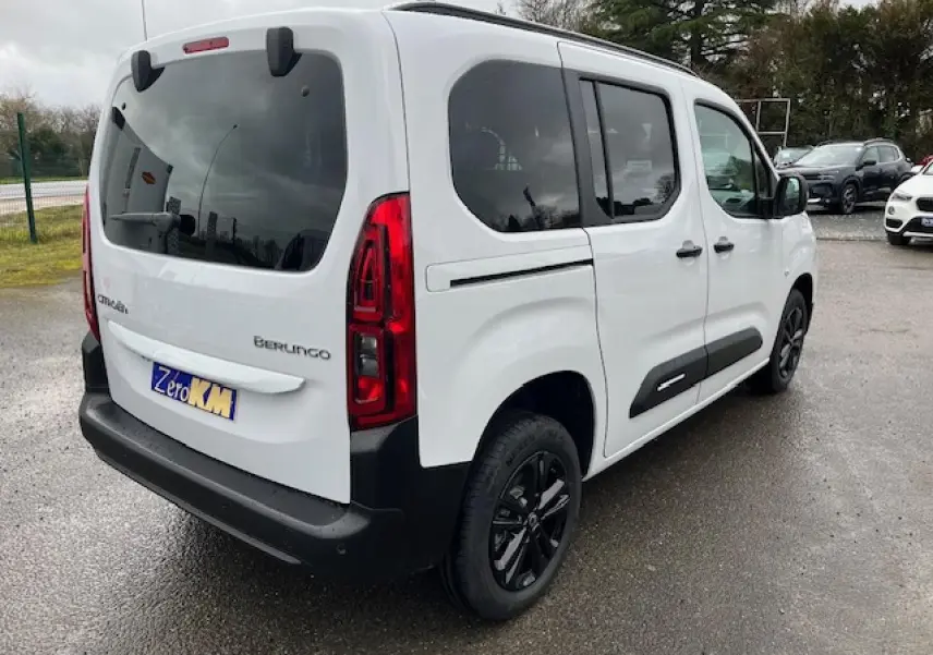 Vue 3/4 arrière droite du Citroën Berlingo Multispace blanc 2025 avec vitres teintées et protections noires sur les portes.
