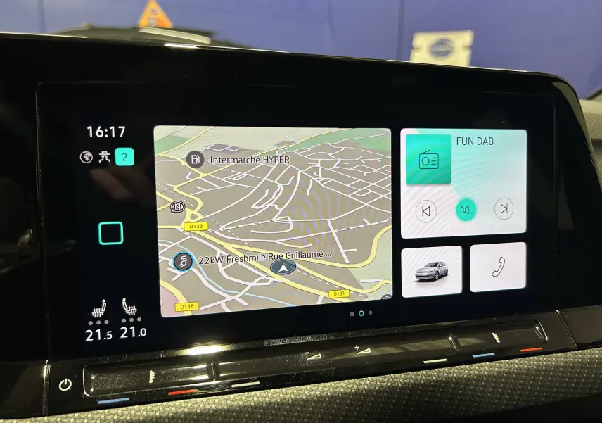 Écran tactile central de la Volkswagen Golf VIII eTSI noir, affichant la navigation et les commandes multimédia.