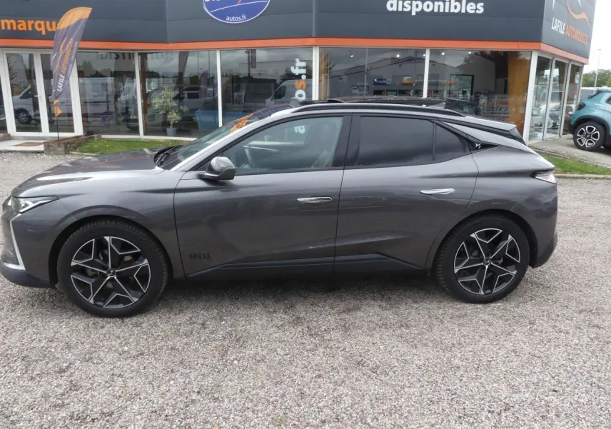 Profil côté gauche d'une DS4 Cross Rivoli gris métallisé avec jantes alliage 19 pouces et vitres teintées.