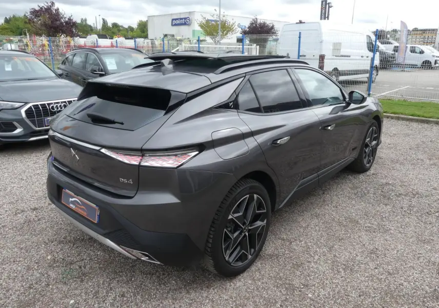 DS4 gris métallisé vu en 3/4 arrière droit, avec feux arrière à effet 3D et jantes alliage noires.