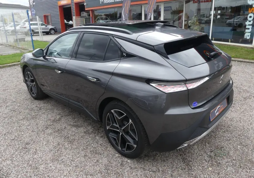 DS4 gris métallisé vu en 3/4 arrière côté gauche, avec jantes alliage noires et toit ouvrant électrique.