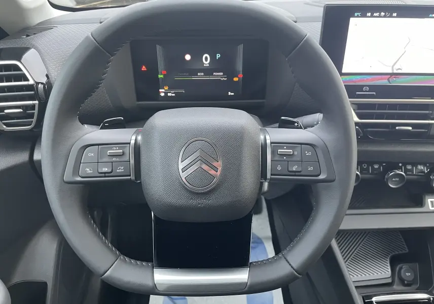 Vue frontale du volant cuir noir de la Citroën C4 1.2 Hybride 145ch avec tableau de bord numérique et écran central tactile.