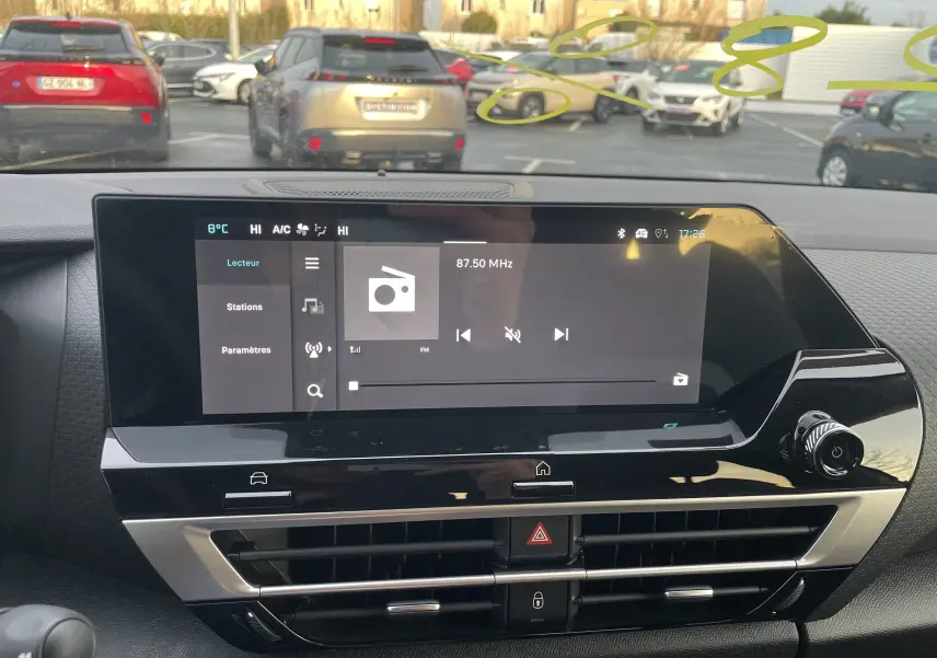 Vue intérieure centrée sur l'écran tactile du tableau de bord de la Citroën C4 2025, avec commandes et ventilation visibles.