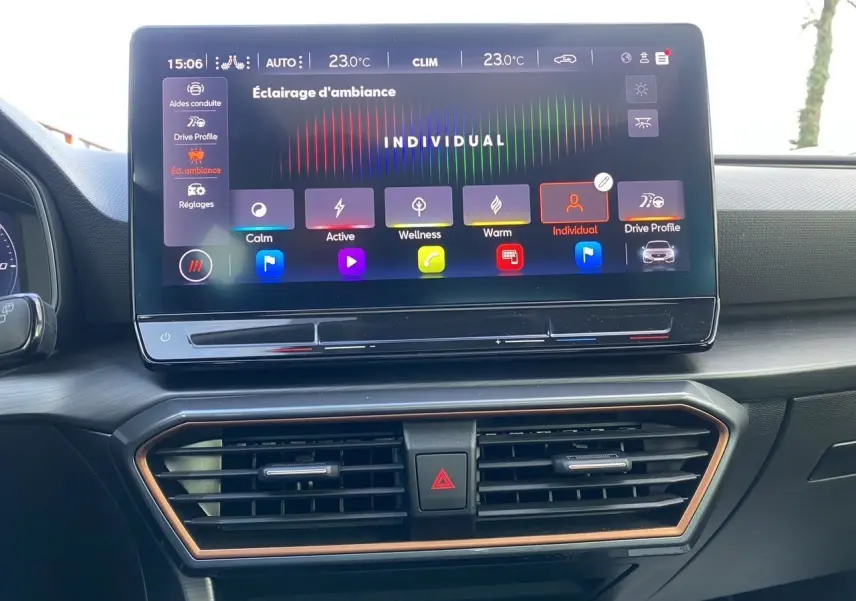 Vue rapprochée de l’écran tactile central et des aérateurs du tableau de bord intérieur noir du CUPRA Leon 2023.