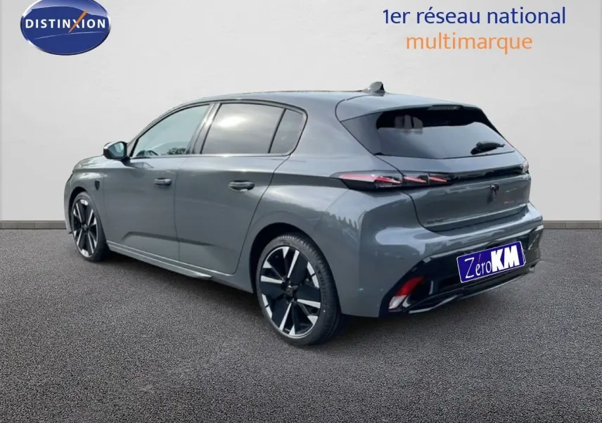 Vue 3/4 arrière droite d'une Peugeot 308 gris selenium métallisé avec jantes noires et feux arrière LED distinctifs.
