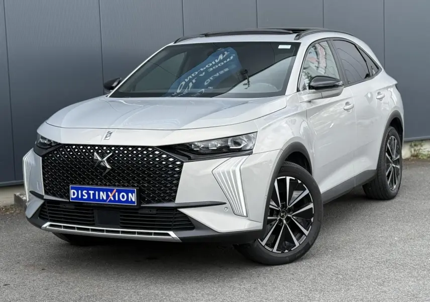 DS7 2025 Cristal Pearl en 3/4 avant droit, avec calandre noire distinctive et jantes alliage 19 pouces.