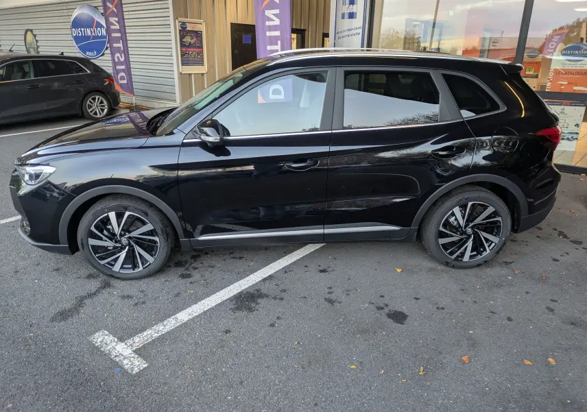 Vue de profil côté gauche du SUV MG ZS noir 2026 avec jantes alliage bicolores et toit panoramique.