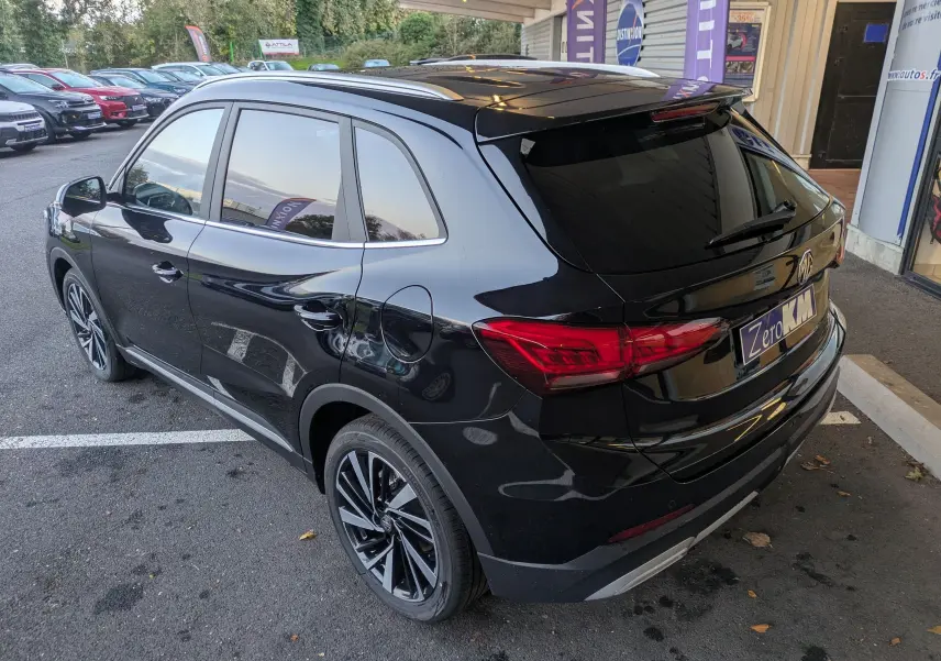Vue 3/4 arrière côté gauche du SUV MG ZS noir 2026 avec toit panoramique et jantes alliage 18 pouces.