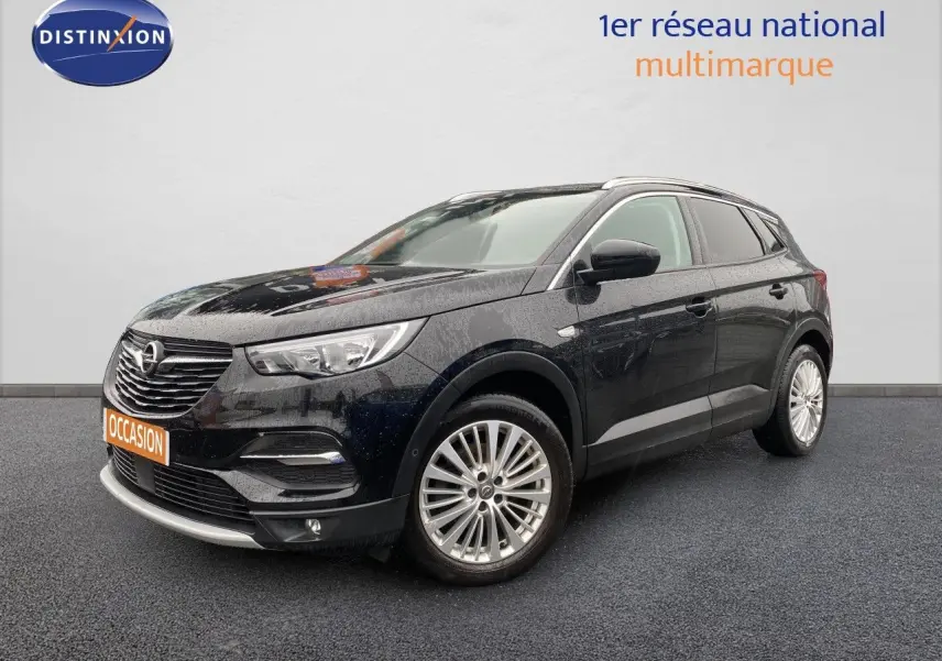 Opel Grandland X noir en 3/4 avant droit, avec jantes alliage et calandre chromée sous un ciel couvert.
