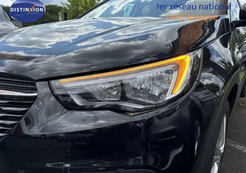 Gros plan sur le phare avant droit d'un Opel Grandland X noir 2019 avec clignotant allumé.