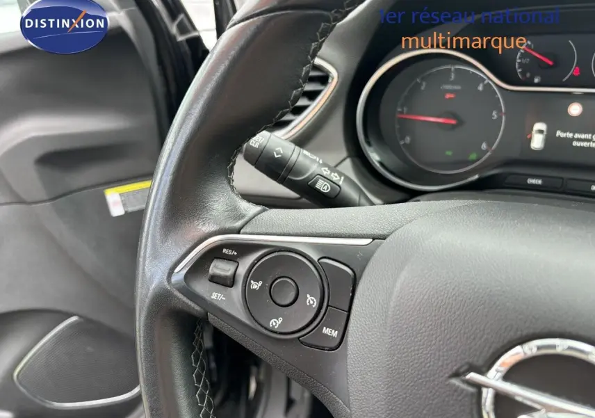 Gros plan sur le volant en cuir noir de l'Opel Grandland X 2019, avec commandes intégrées et tableau de bord visible.