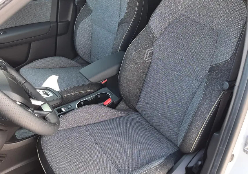 Gros plan sur les sièges avant en tissu gris du Renault Symbioz 2024, version hybride essence, intérieur soigné et moderne.