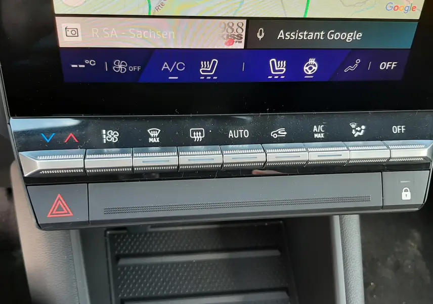 Gros plan sur la console centrale du Renault Symbioz 2024, montrant les commandes tactiles de climatisation et le bouton de warning.