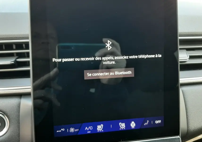 Écran tactile central du tableau de bord du Renault Symbioz gris Rafale, affichant la connexion Bluetooth et commandes climatisation.