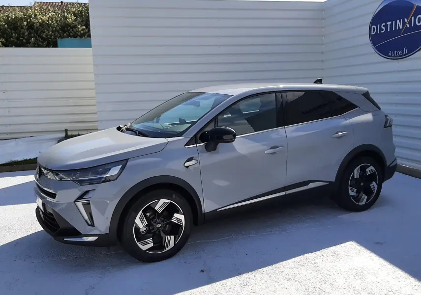 Renault Symbioz gris Rafale en vue 3/4 avant droit, SUV hybride avec jantes noires et détails modernes sur carrosserie.