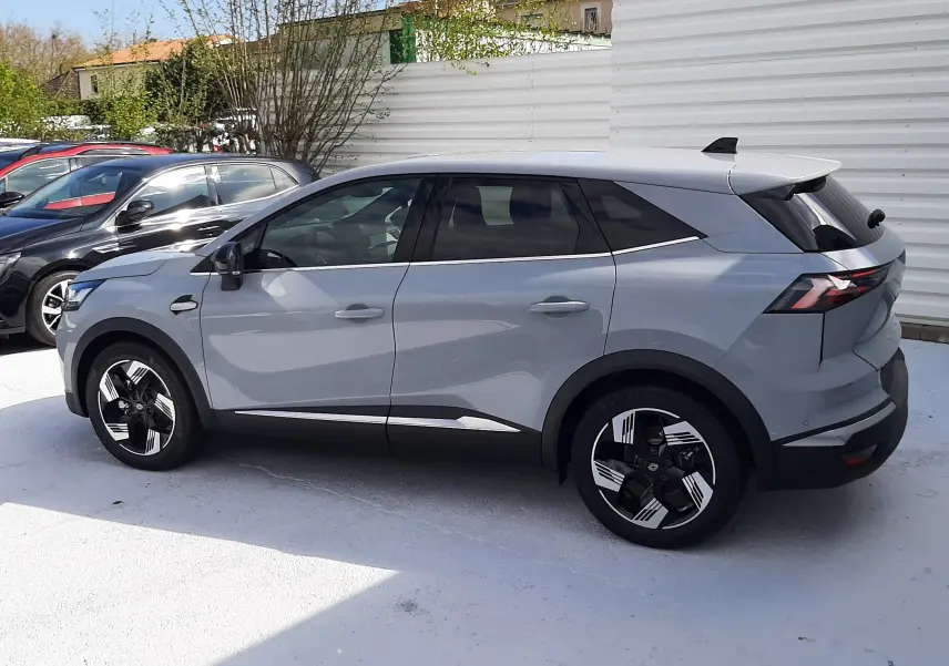 Renault Symbioz gris Rafale en vue de profil côté gauche, SUV hybride 2024 avec jantes noires et détails chromés.