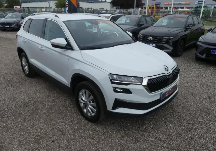 SUV SKODA KAROQ blanc en vue 3/4 avant droit, avec calandre noire et jantes alliage 17 pouces visibles.
