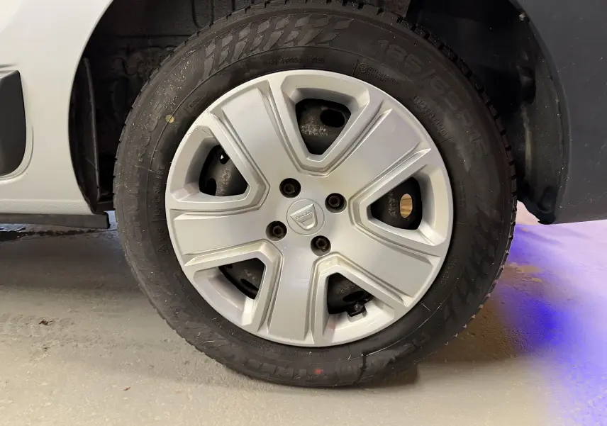 Vue rapprochée de la roue arrière droite d'un Dacia Dokker gris 2019, montrant le passage de roue et le pneu.