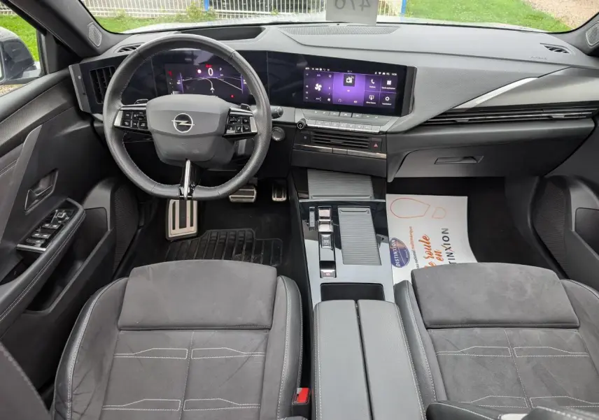 Vue intérieure de l’Opel Astra 2024 gris métallisé, tableau de bord moderne avec écran tactile et volant multifonction.