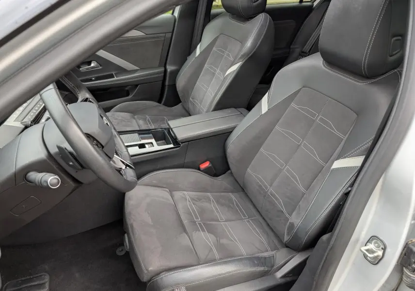 Vue intérieure côté conducteur de l’Opel Astra 2024 gris métallisé, avec sièges en cuir et alcantara gris foncé.