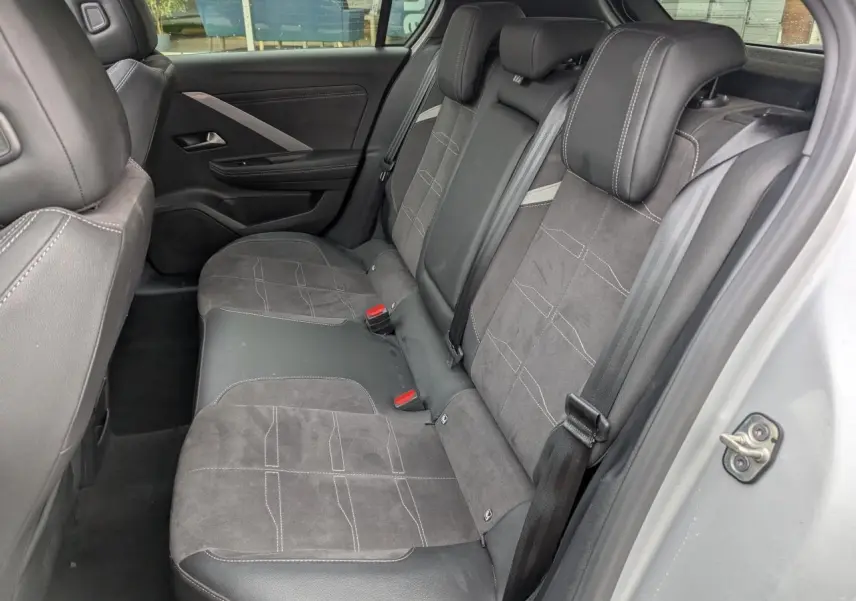 Vue intérieure côté droit des sièges arrière en tissu et cuir noir de l’Opel Astra 2024 gris métallisé.