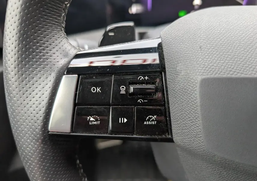 Gros plan sur les commandes à gauche du volant en cuir perforé de l'Opel Astra 2024 gris métallisé, version Ultimate.