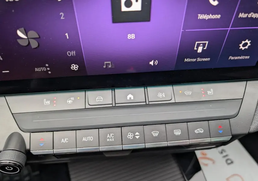 Vue rapprochée du tableau de bord de l’Opel Astra 2024 gris métallisé, mettant en valeur les commandes climatisation et sièges chauffants.