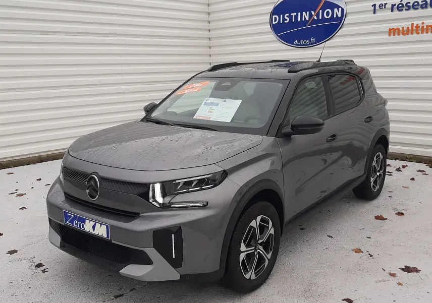 Vue 3/4 avant d'une Citroën C3 Aircross hybride gris avec toit noir, roues alliage et feux LED allumés.