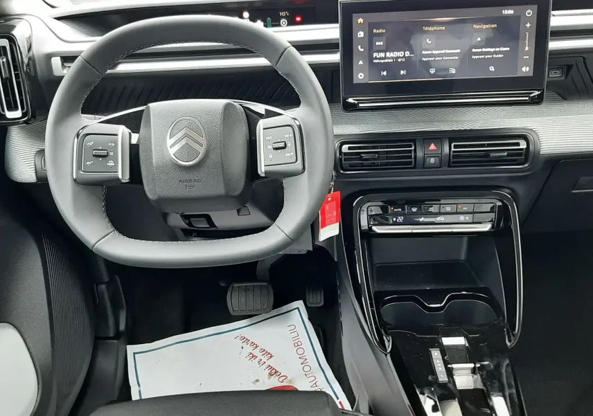 Vue intérieure avant centrée sur le volant et la console centrale du Citroën C3 Aircross hybride 2025, avec écran tactile et finition noire.