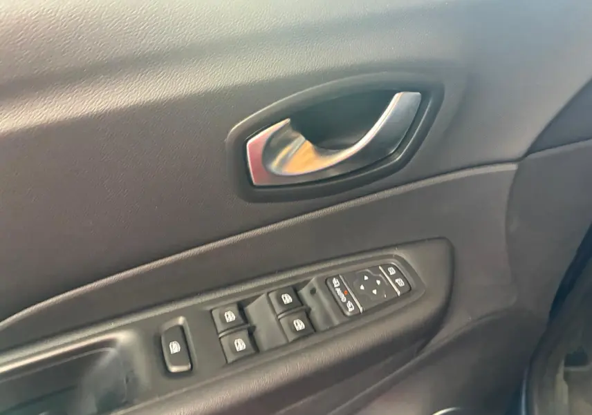 Gros plan sur la porte intérieure côté conducteur du Renault Captur 2017, avec commandes électriques des vitres et poignée argentée.