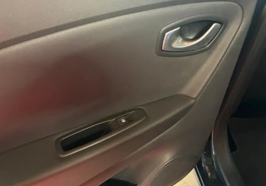Gros plan sur la porte intérieure côté conducteur du Renault Captur bleu 2017, avec poignée et bouton de vitre électrique.