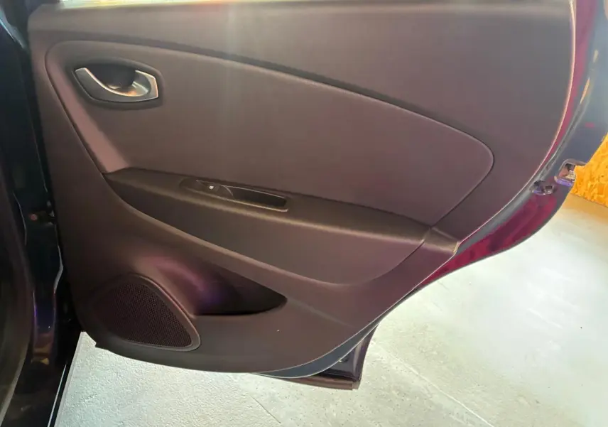 Vue intérieure de la porte arrière gauche du Renault Captur bleu 2017, avec panneau noir et haut-parleur intégré.