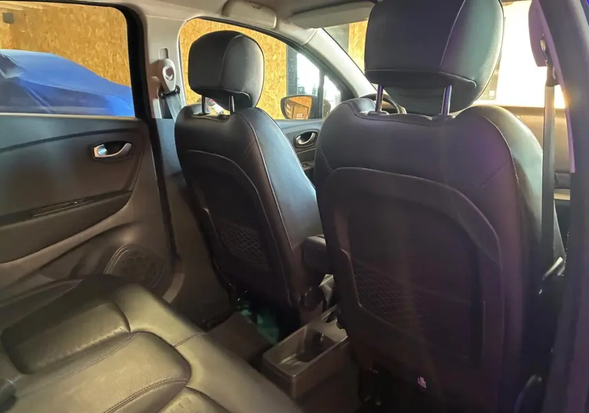 Vue intérieure arrière du Renault Captur 1.5 DCI 90 Intens 2017, sièges avant en cuir noir et banquette arrière en tissu.