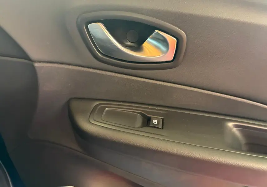 Poignée intérieure de porte côté gauche en plastique noir avec bouton de commande de vitre sur Renault Captur bleu 2017.