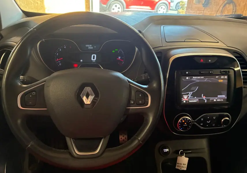 Vue intérieure centrée sur le volant noir Renault Captur 1.5 DCI 90 Intens avec tableau de bord et écran GPS allumé.